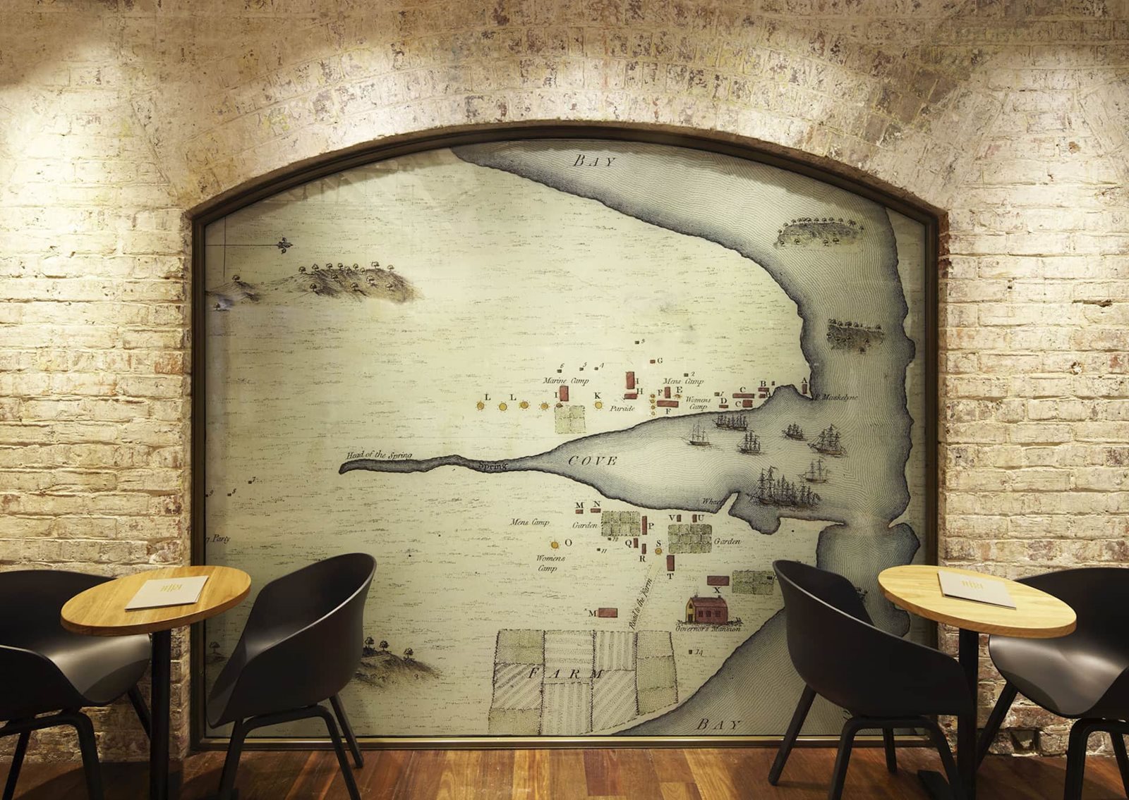 Rustic Eric's Bar seating set against an exposed brick wall and historical map artwork